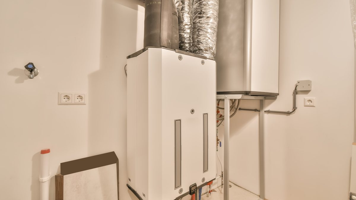 White storage water heater standing against a plain wall
